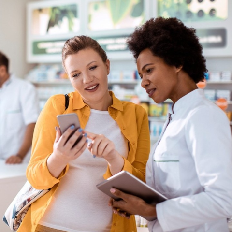 Two women looking at a phone.